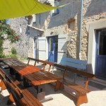 Les tables de jardin sous les voiles d'ombrage du gite de groupe