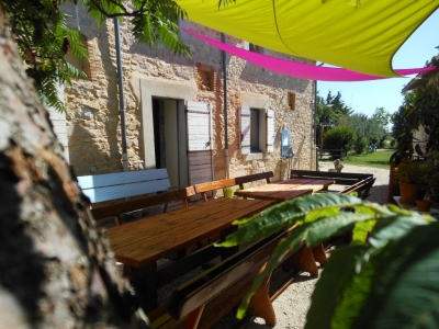 Les tables de jardin sous les voiles d'ombrage du gite de groupe