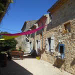 Les tables de jardin sous les voiles d'ombrage du gite de groupe