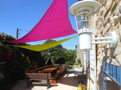 Les tables de jardin sous les voiles d'ombrage du gite de groupe